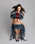 KROMANOX ART001 Braided Bloom Cape and ART002 Braided Bloom Skirt in motion, showing layered braided denim movement and texture